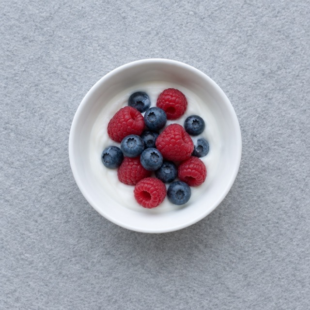 Soy yogurt with berries in a small bowl, a plant-based high protein vegan snack